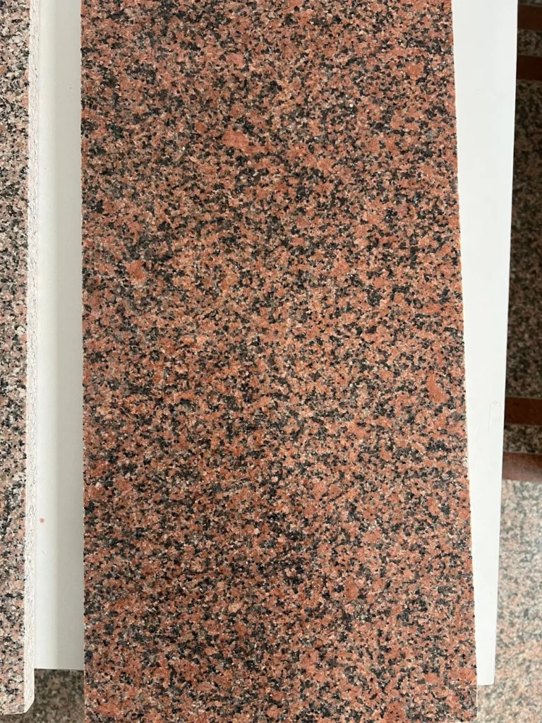 Long red-and-black speckled stone piece between pale dividers.